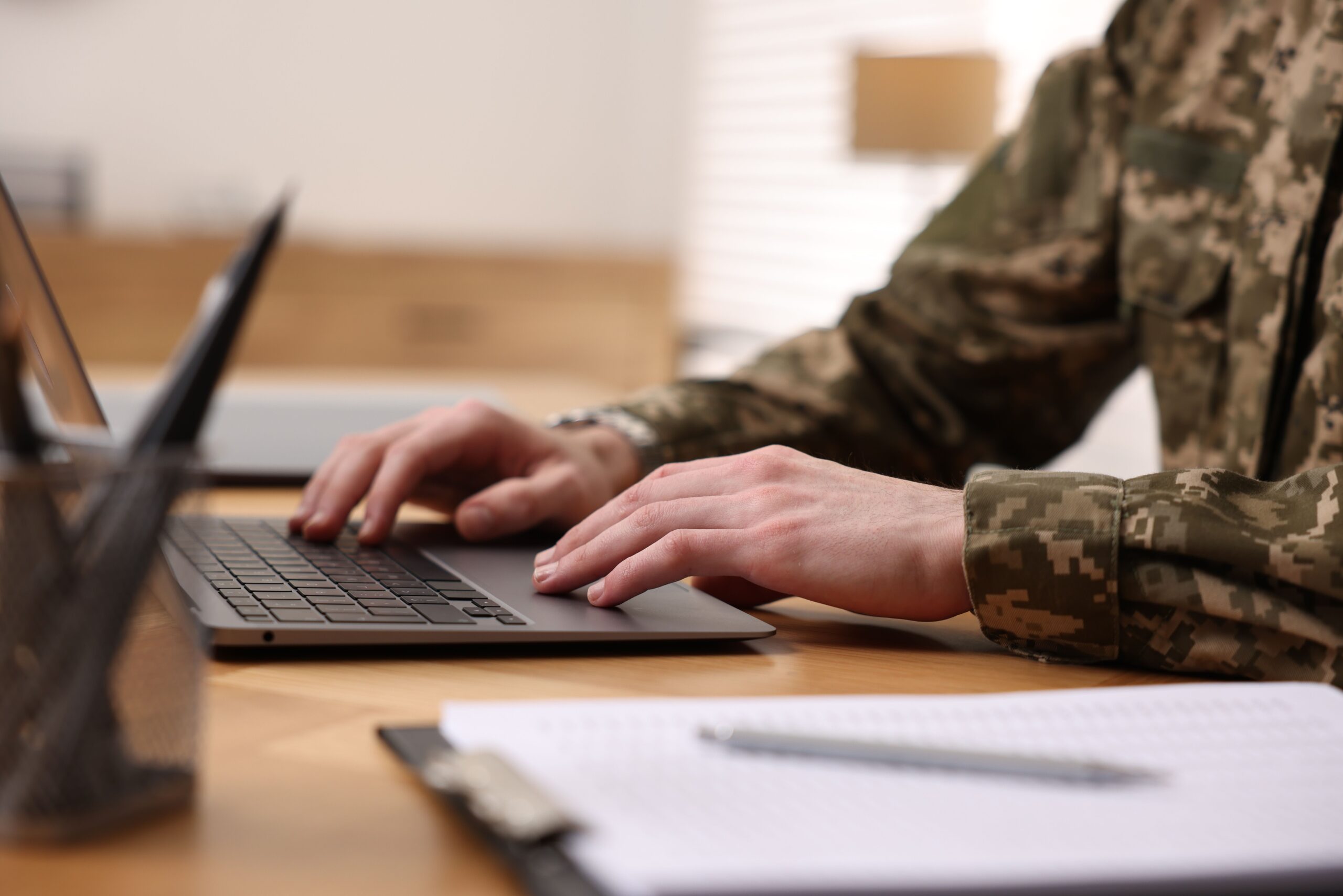 Military,Service.,Soldier,Working,With,Laptop,At,Wooden,Table,Indoors,